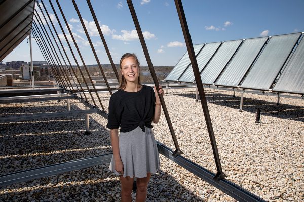 Leah Johnson poses for a portrait near the rooftop solar panels on Leopold Residence Hall at UW-Madison.